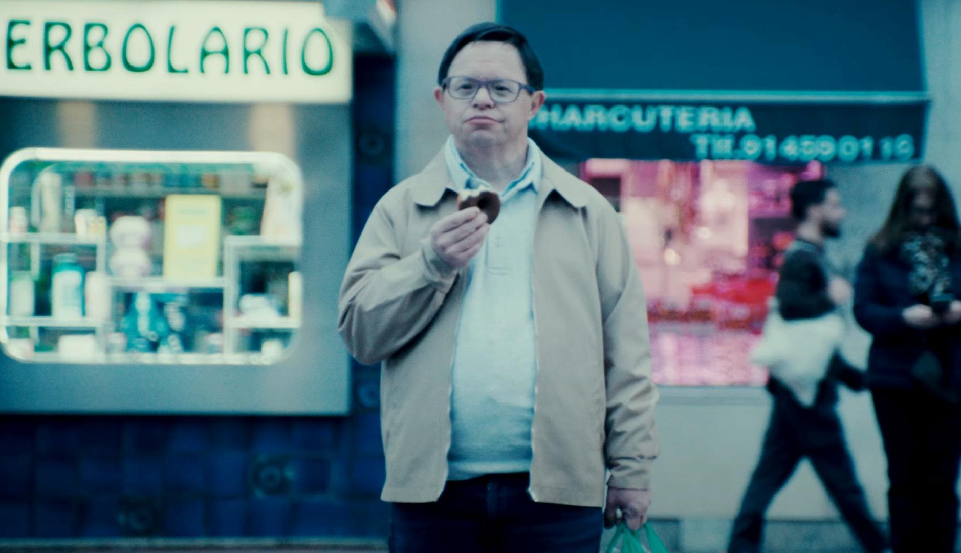 persona con síndrome de down comiendo un bollo en la calle