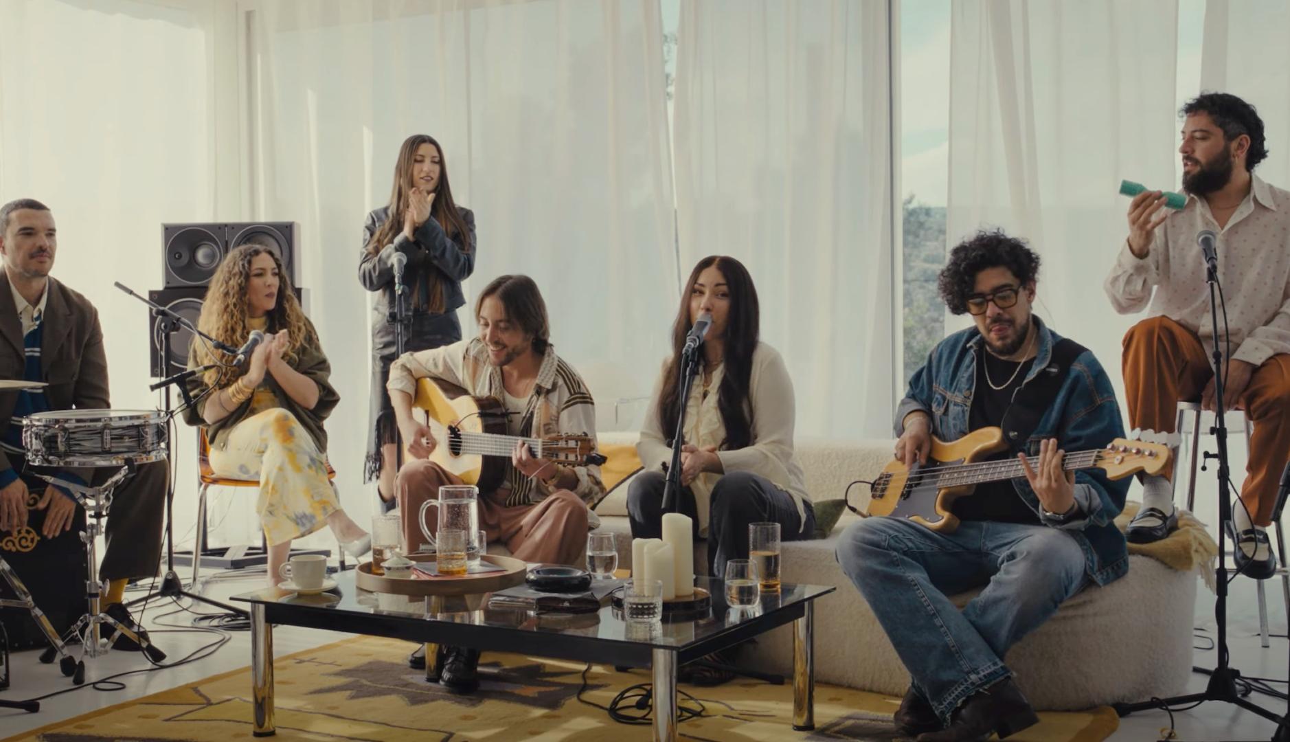 Grupo de músicos interpretando una canción en un salón.