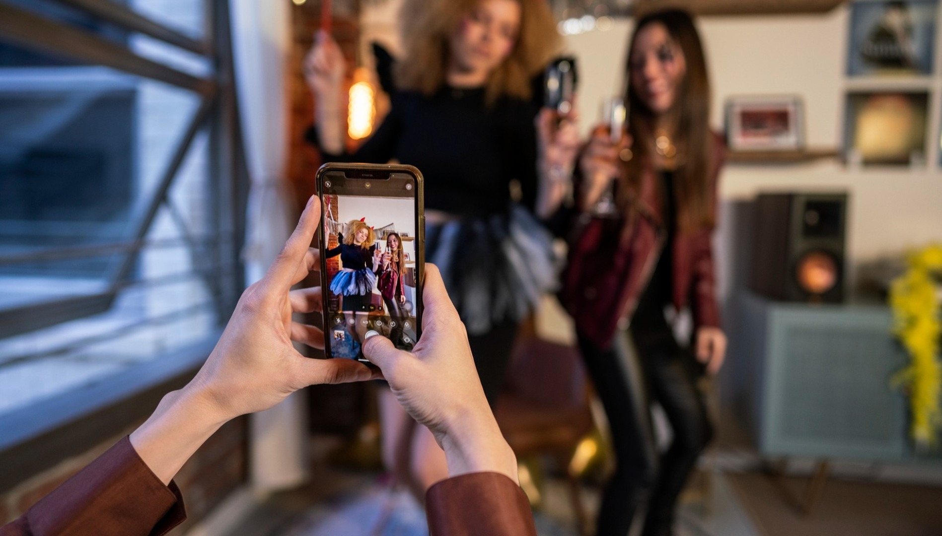 Una joven grabando a otras dos un vídeo para TikTok