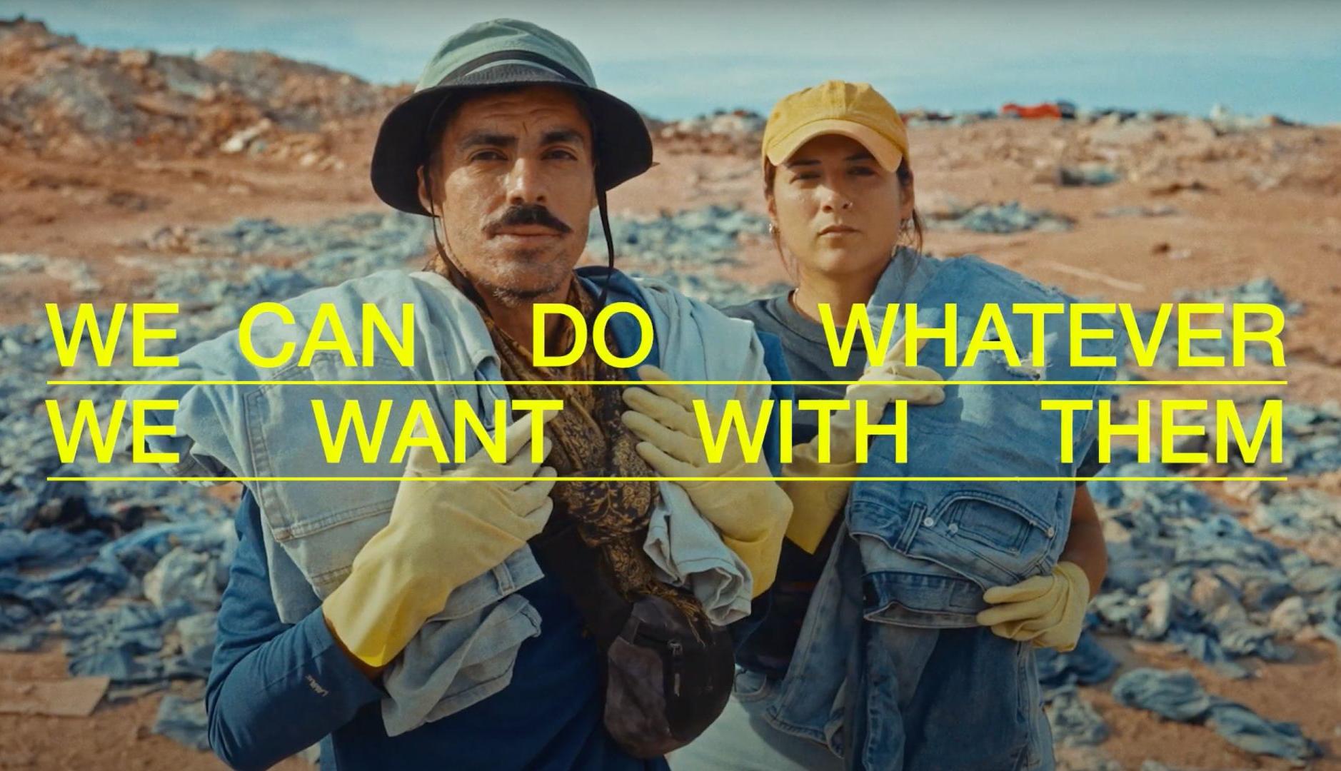 Un hombre y una mujer sujetan prendas rescatadas en el desierto de Atacama