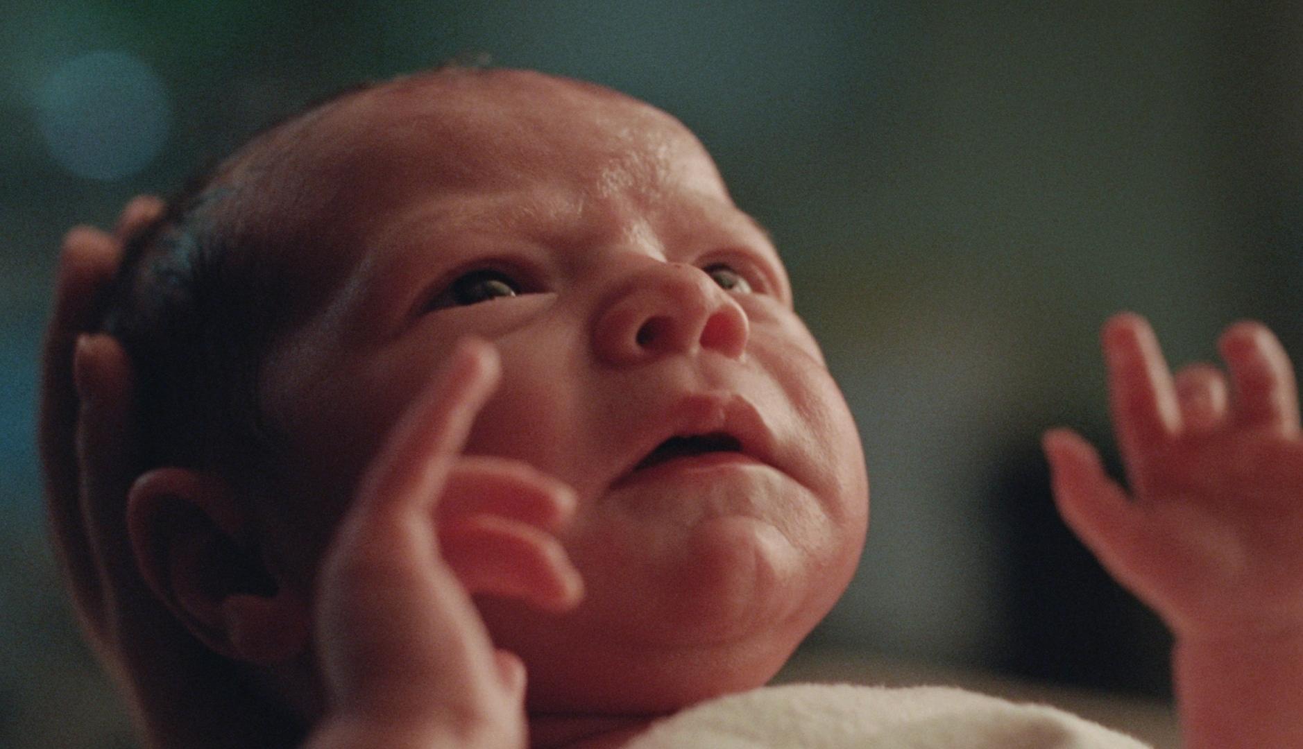 Bebé recién nacido mirando hacia arriba para tomar su primera bocanada de aire