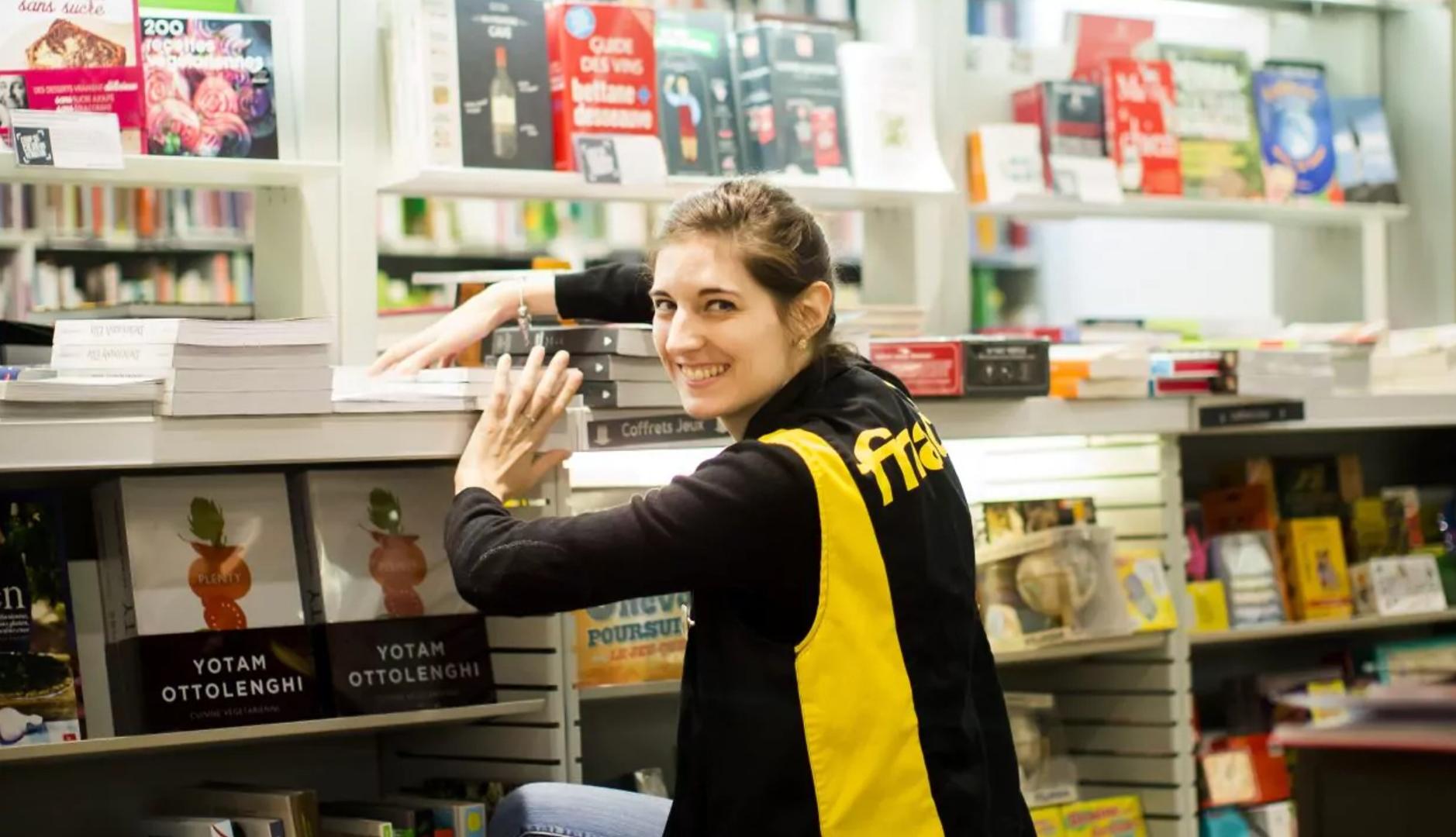 Empleada de Fnac colocando libros