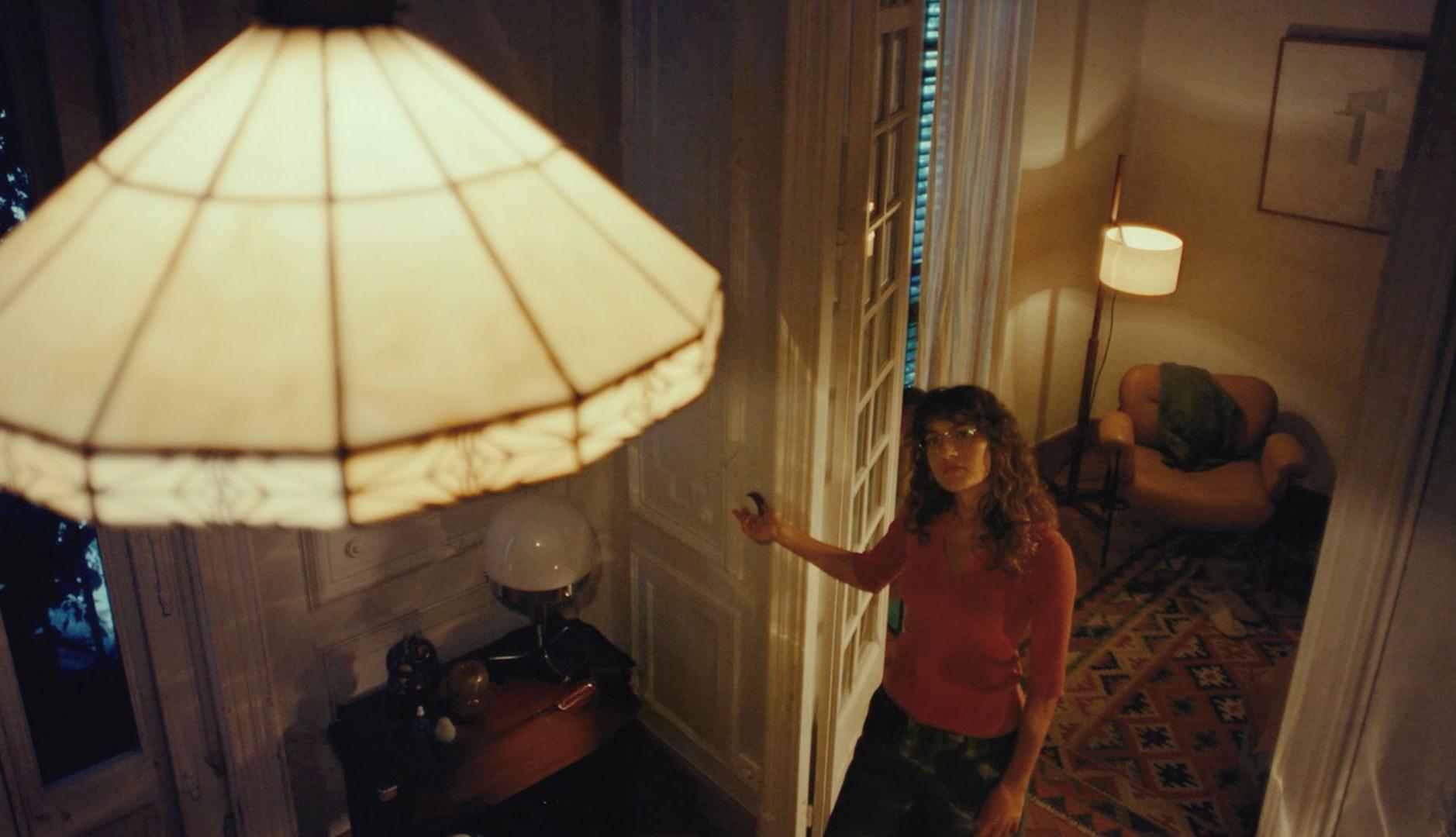 Chica pulsando un interruptor para encender una lámpara