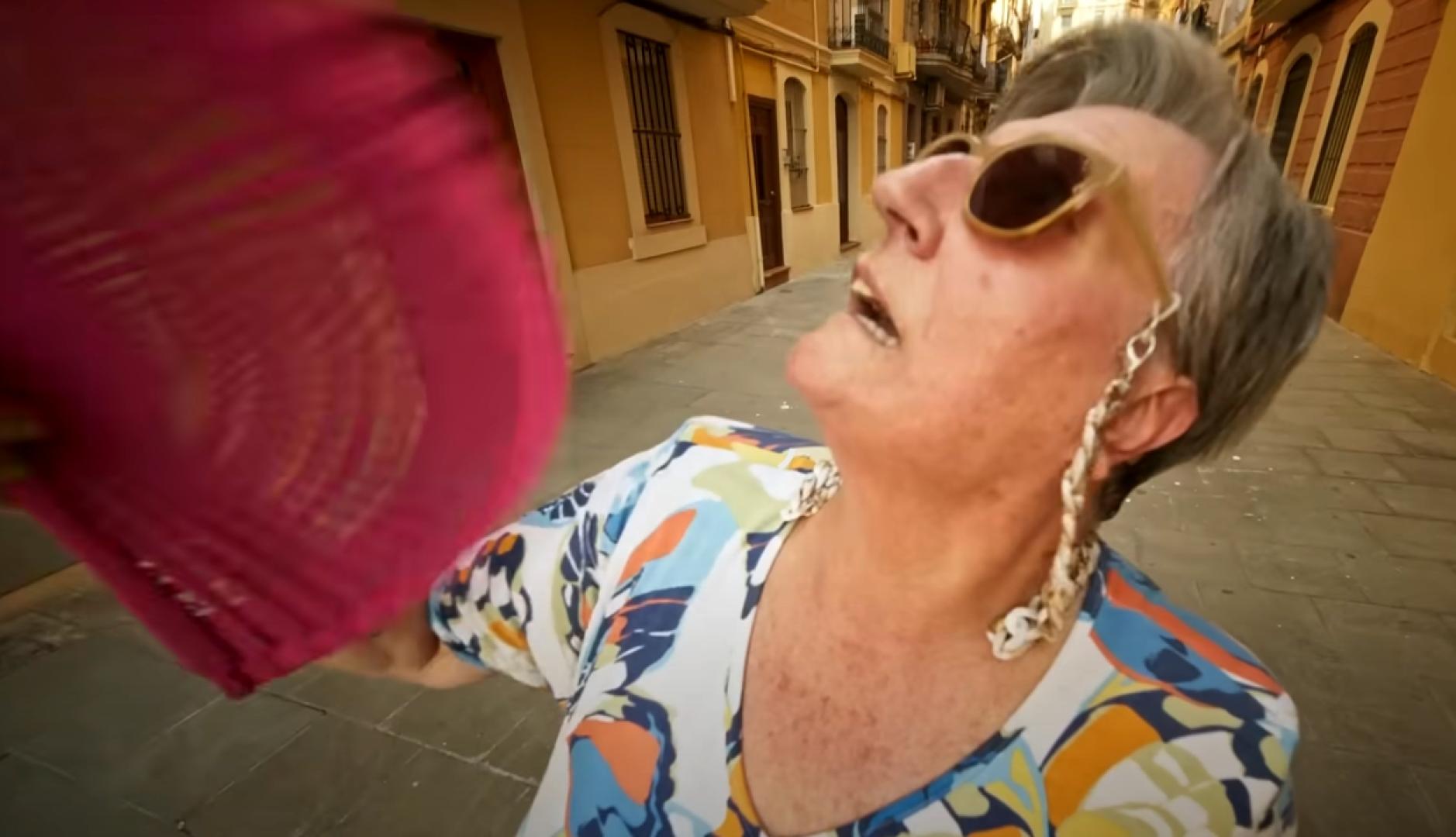 una señora abanicándose con expresión de calor
