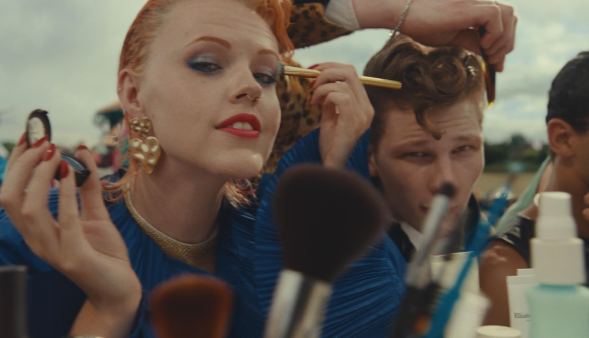 Una chica pelirroja maquillándose, es un frame del anuncio