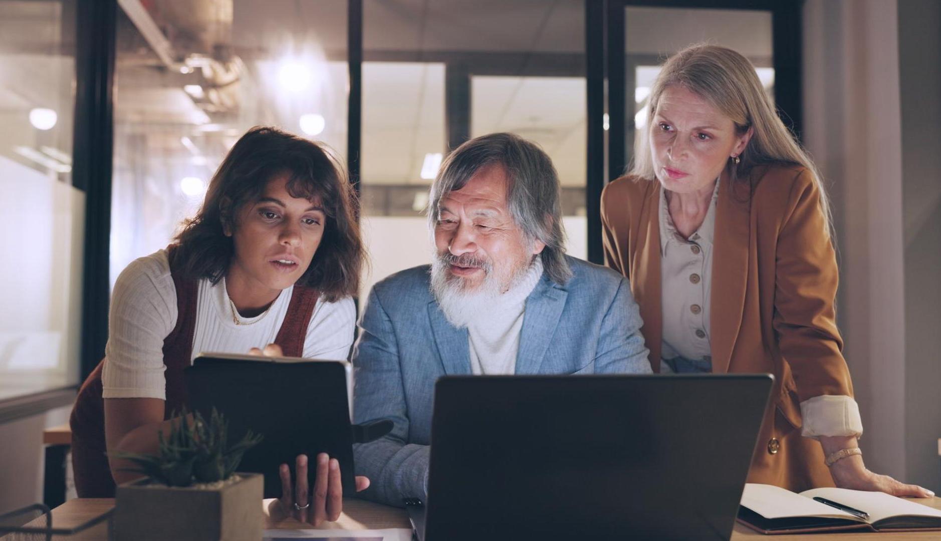 Tres personas en el trabajo delante de un ordenador