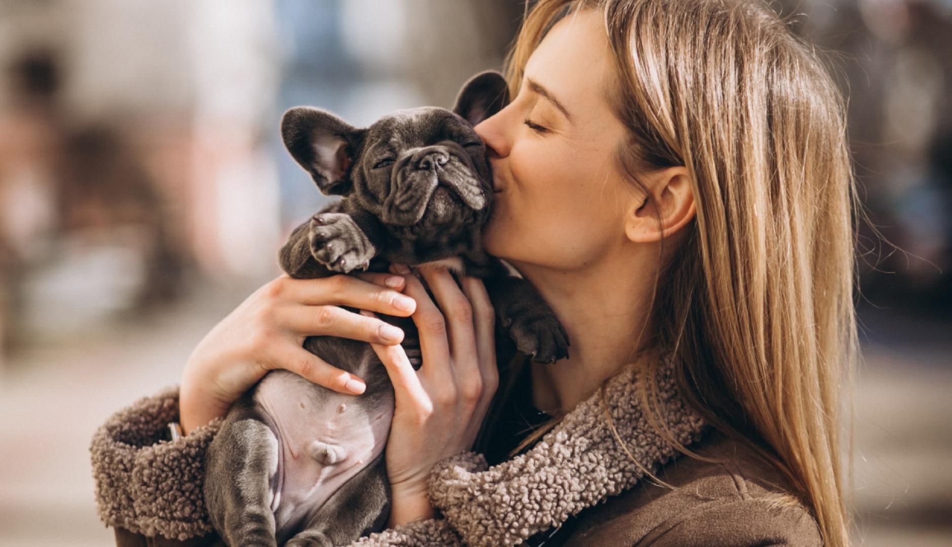 una chica abrazando y dando un beso a su perro
