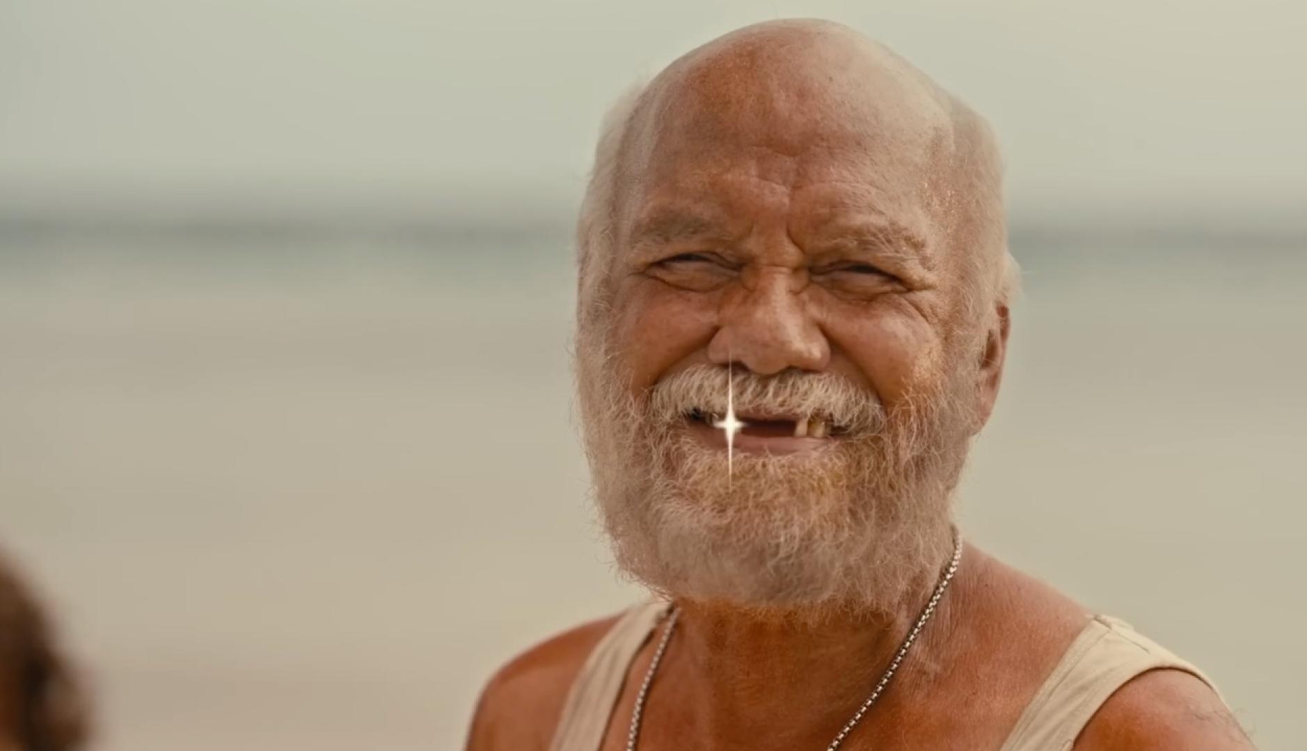 Un hombre mayor desdentado con un destello en uno de los dientes