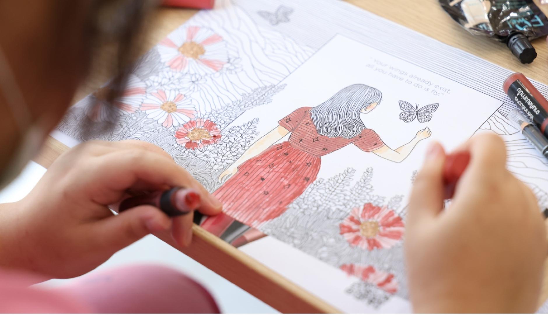 Una niña pintando un dibujo con labiales de L'Oréal