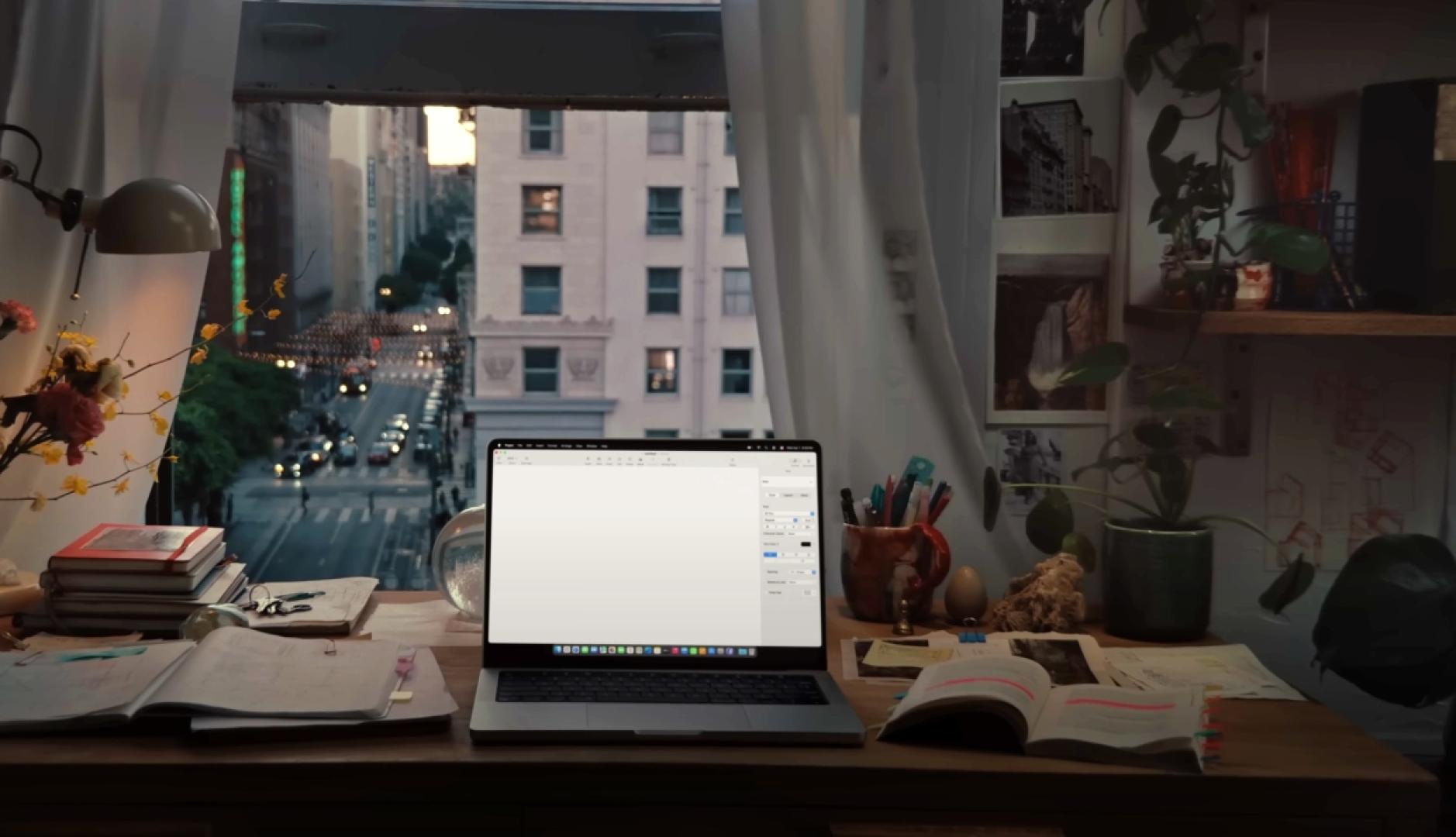 un escritorio de una casa con un Mac encendido y vistas a las calles de Nueva York por la ventana