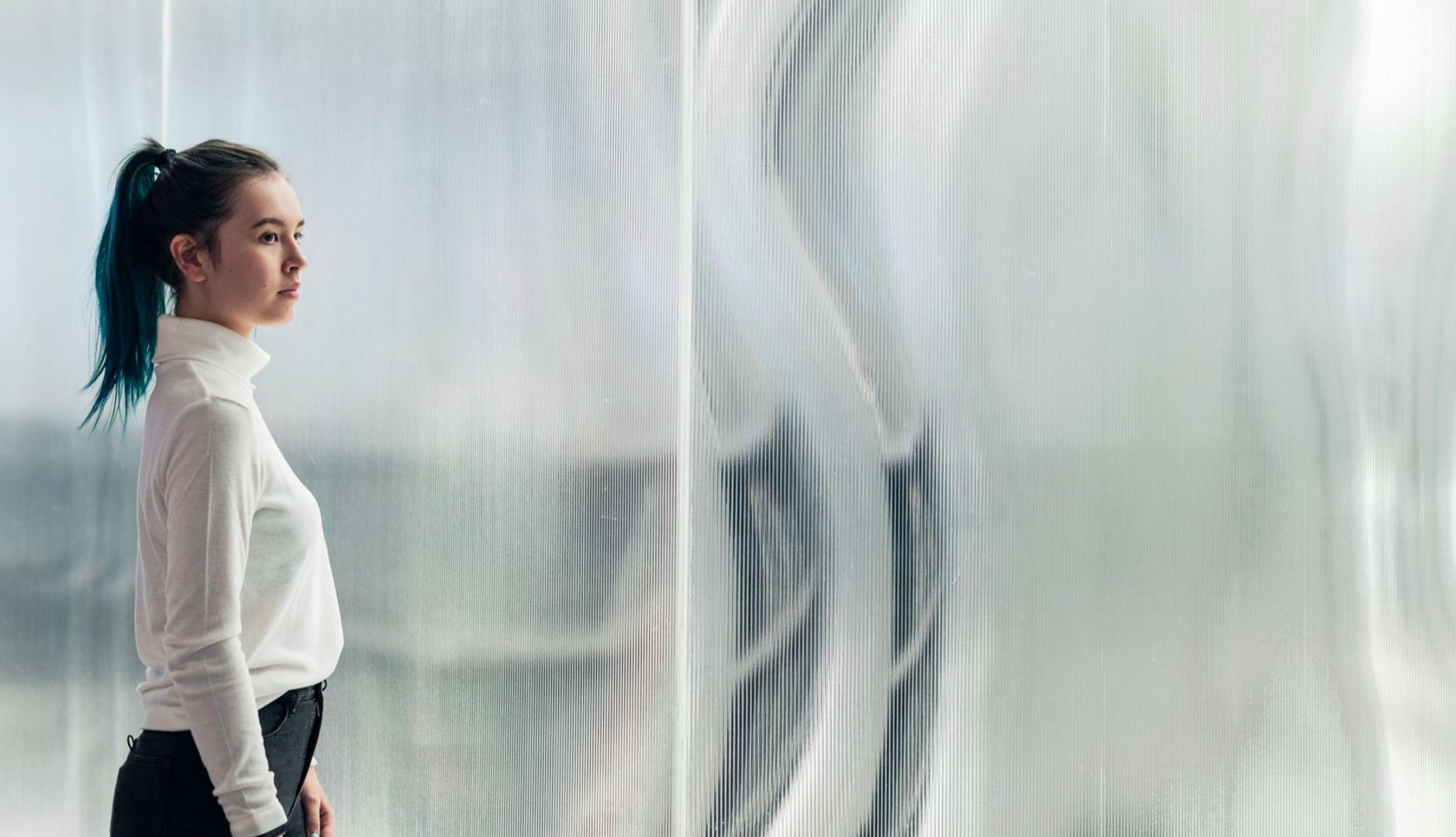 Chica frente a panel vidrioso