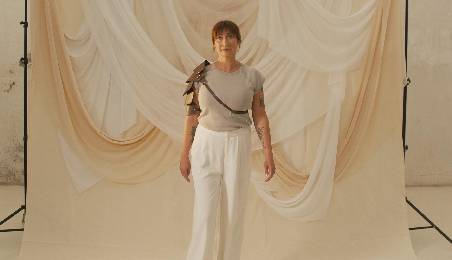 Mujer con armadura de guerrera ante fondo claro