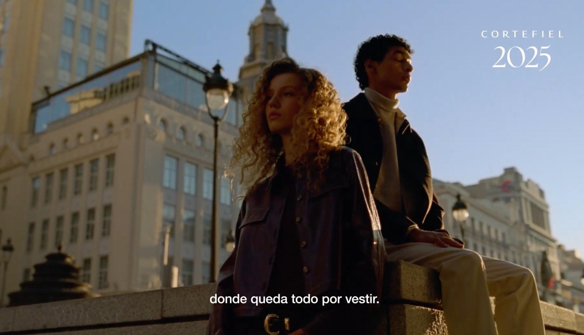 Dos jovenes ante edificios de la Gran Vía de Madrid en un annuncio de Cortefiel