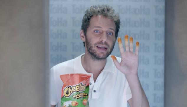 Un hombre enseñando los dedos naranjas por el polvo de los Cheetos