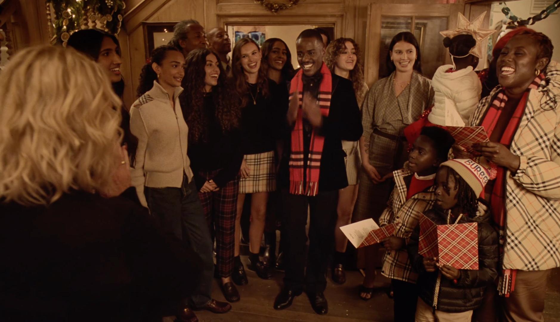Grupo de personas cantan villancicos en el anuncio de Navidad de Burberry