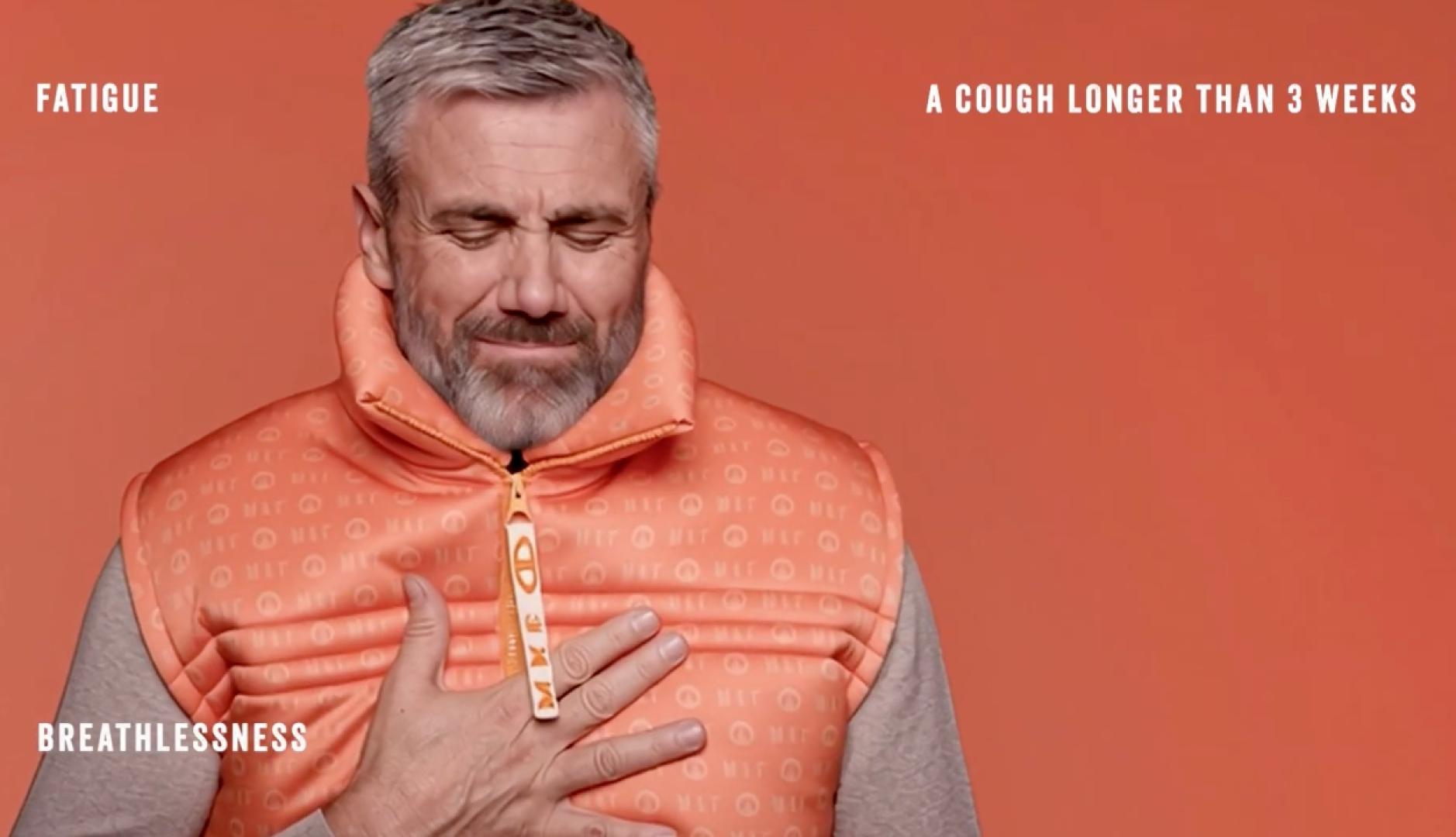 Un hombre con el chaleco de la colección llevándose la mano al pecho con rostro de incomodidad