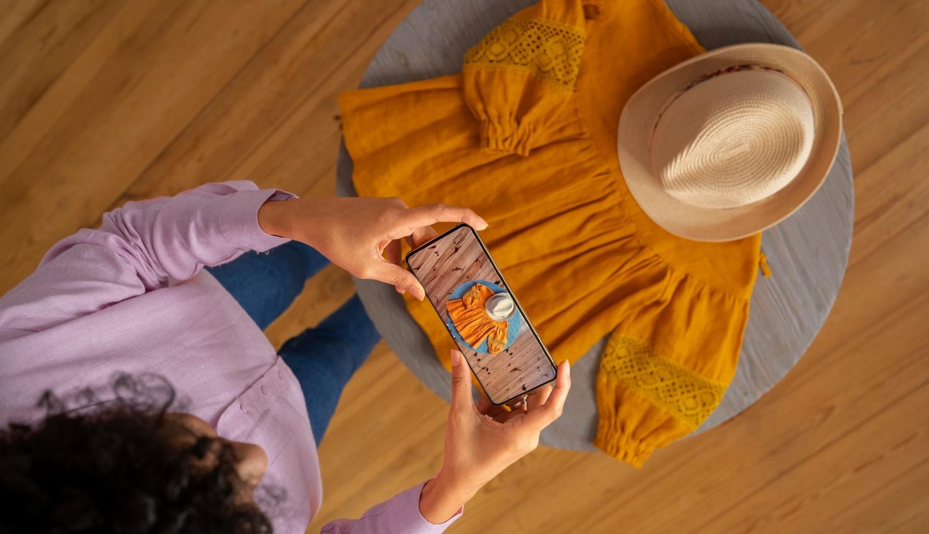 Una chica fotografía un vestido con el móvil