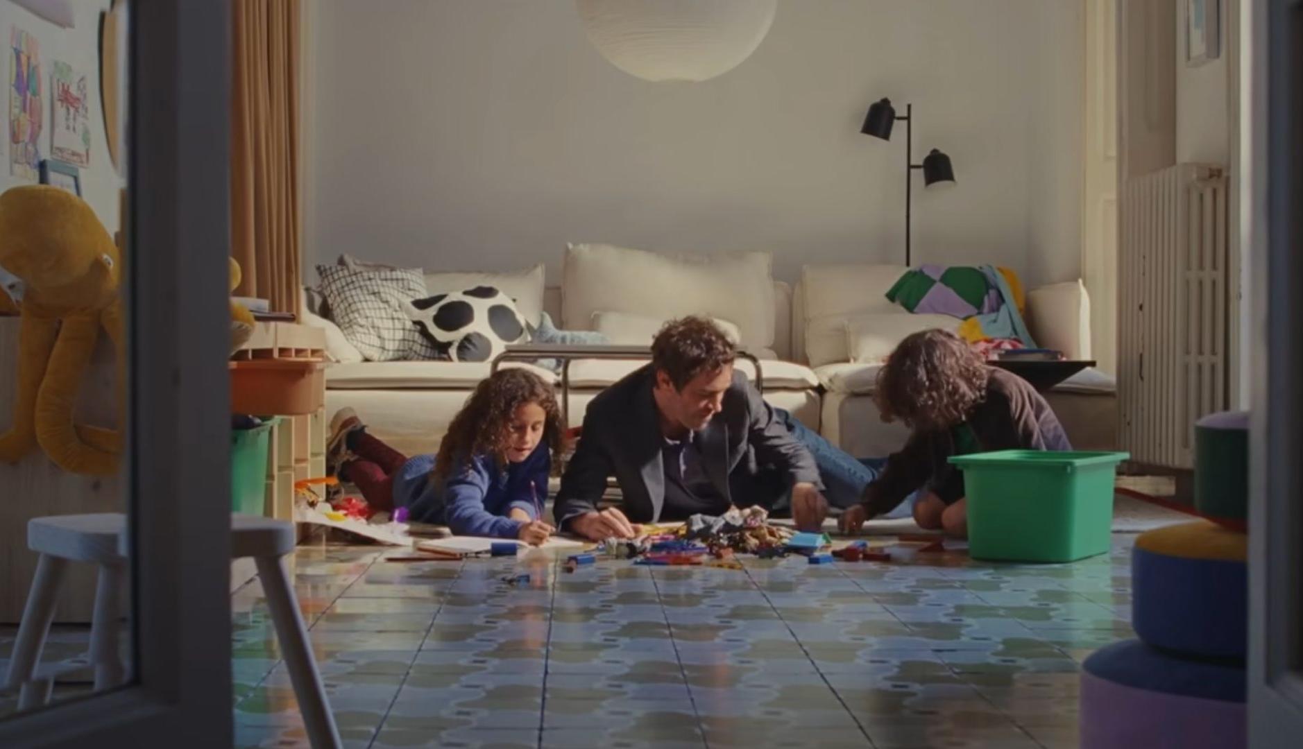 Un hombre juega con sus hijos en el salón de casa