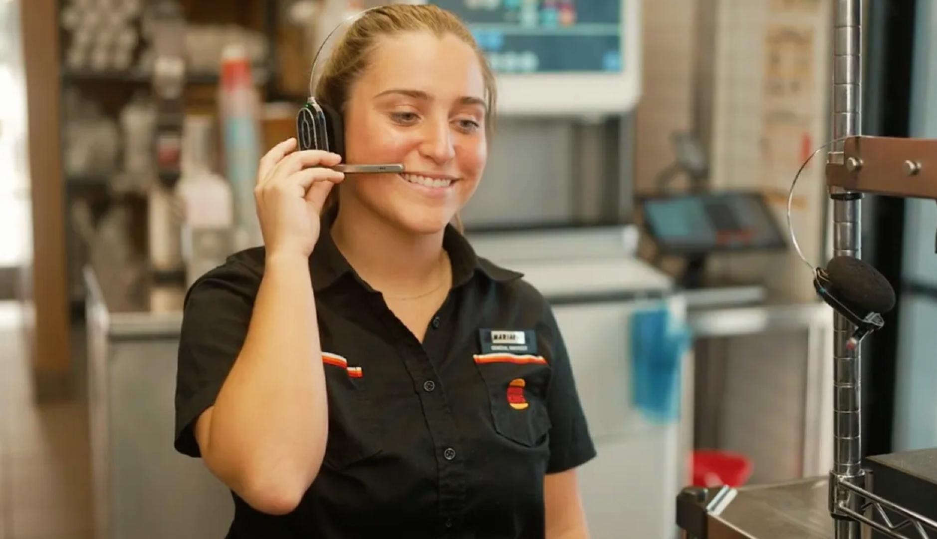 Una empleada de Burger King colocándose el micrófono de los auriculares