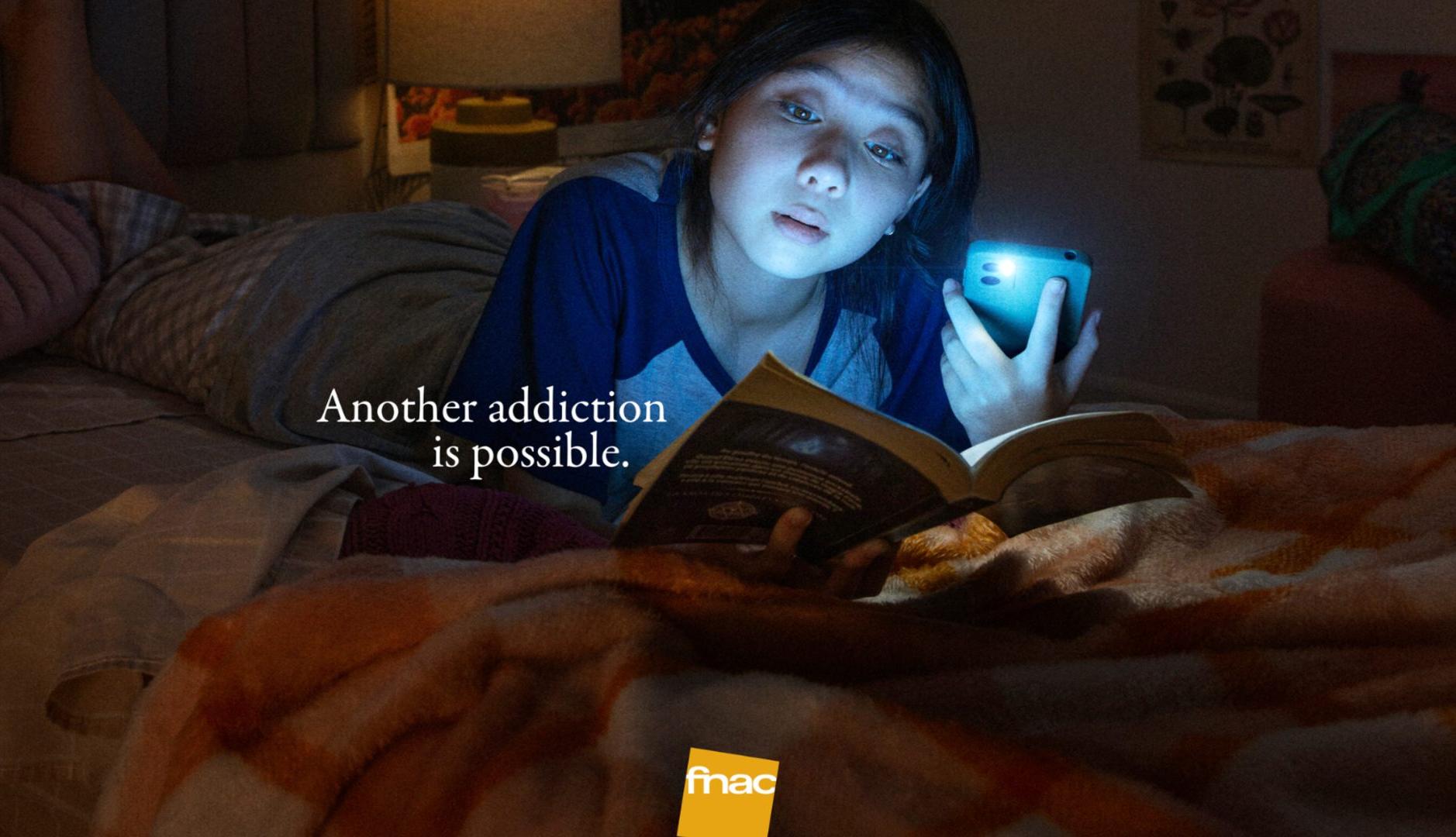 Joven lee un libro iluminado con la linterna del teléfono