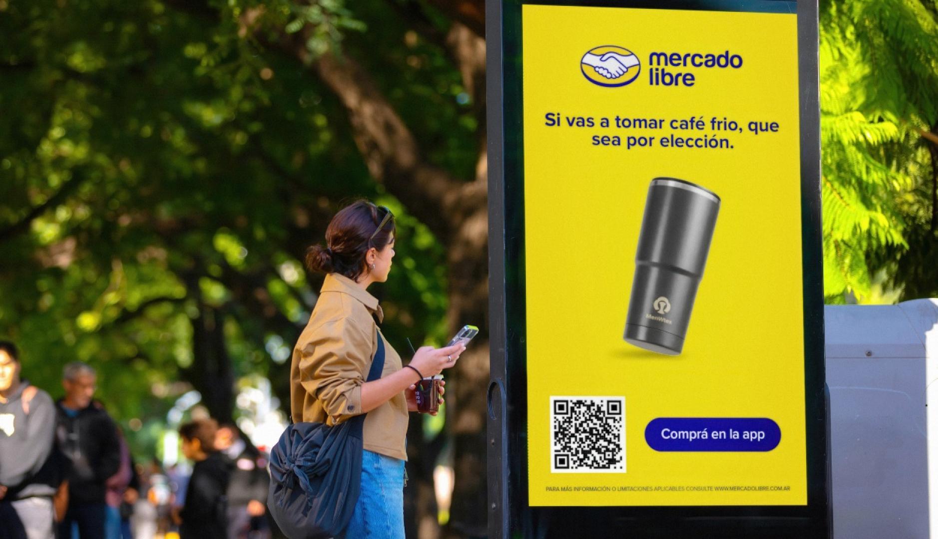 Una chica se detiene ante el mupi de Mercado Libre para leer el mensaje