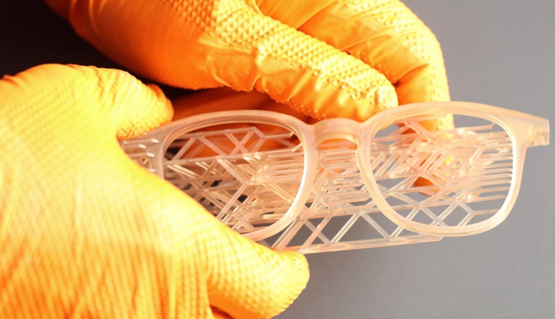 Unas manos con guantes sosteniendo unas gafas hechas en 3D
