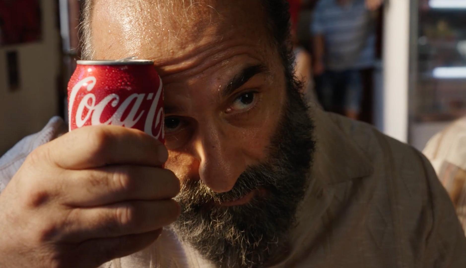 Un hombre refresca su frente con una lata de Coca-Cola