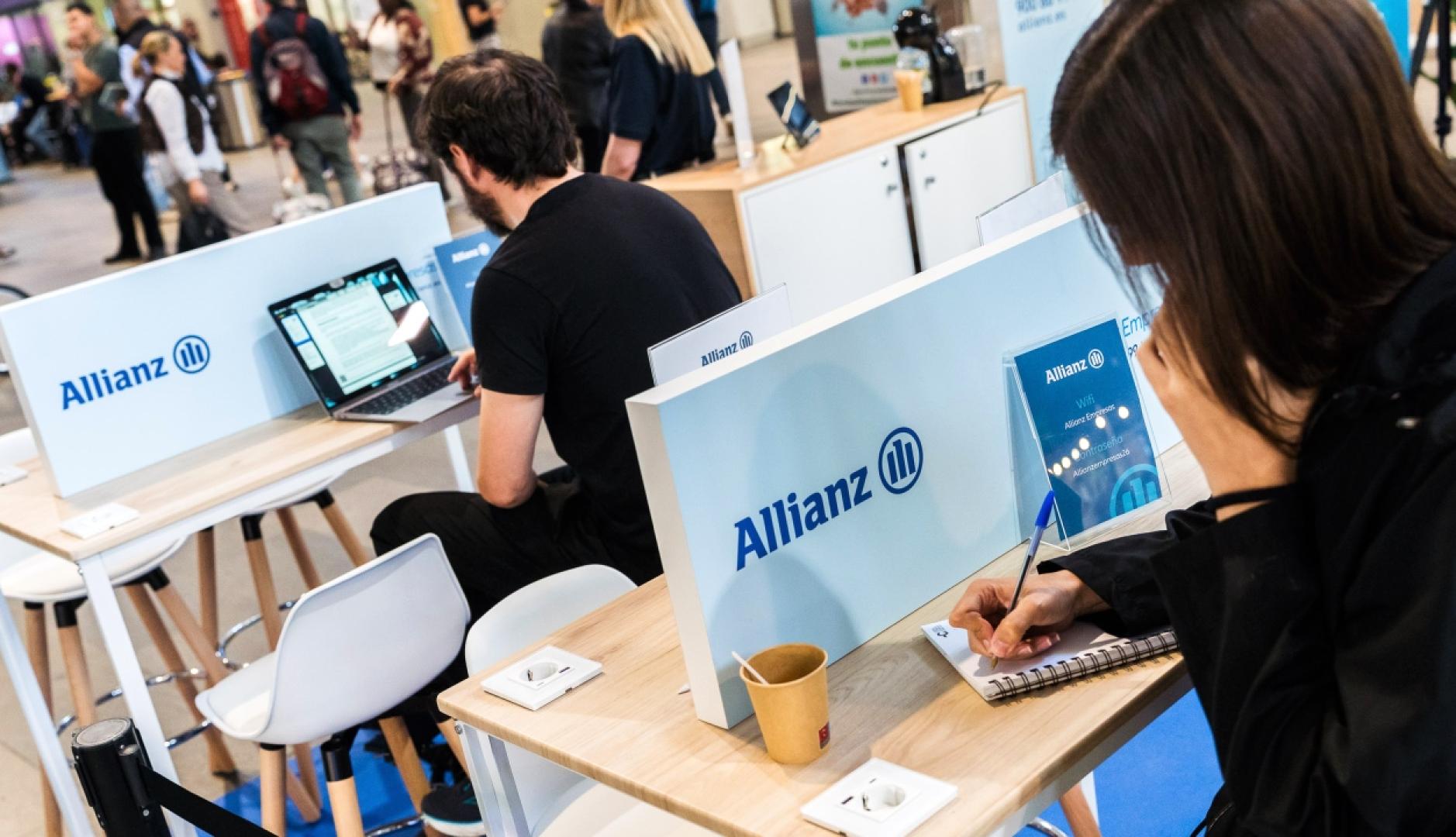 Personas trabajando en la cabina de Allianz dentro de la estación de tren
