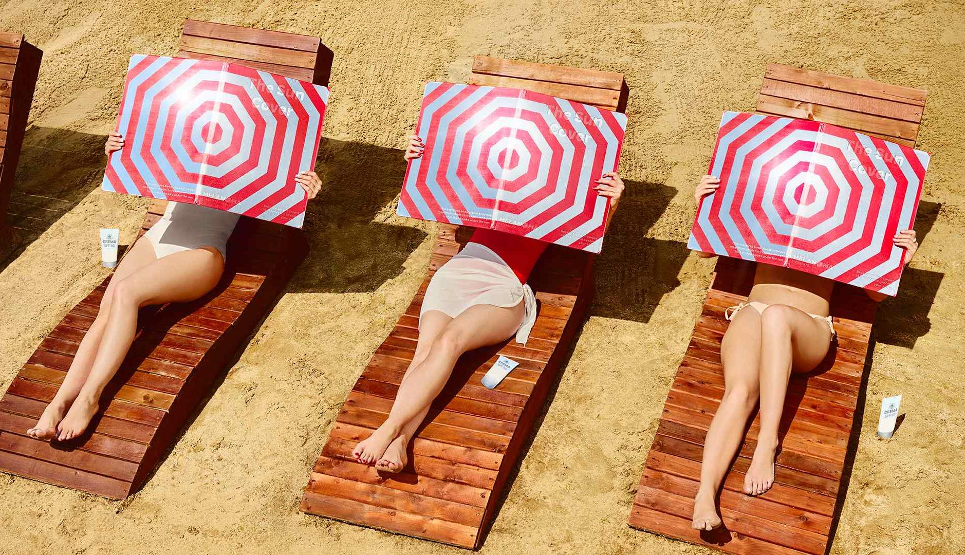 Mujeres sujetan un reflector invertido en la playa