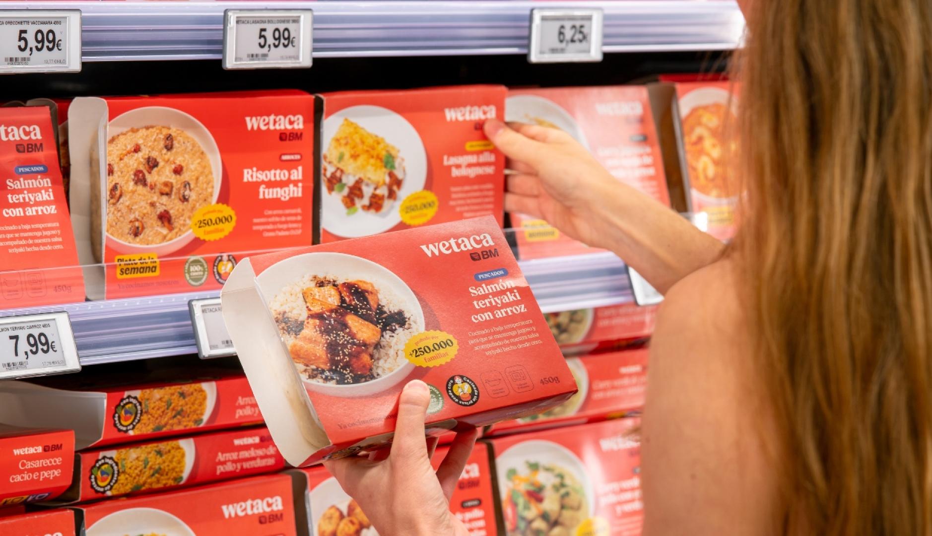 Una chica cogiendo cajas de Wetaca del lineal del supermercado